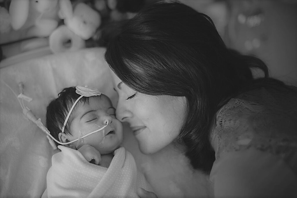 Black and white image of woman laying with her baby.