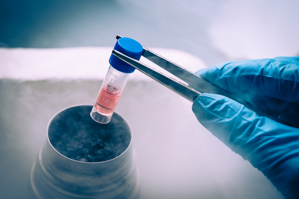 Scientist picking up a test tube with tweezers