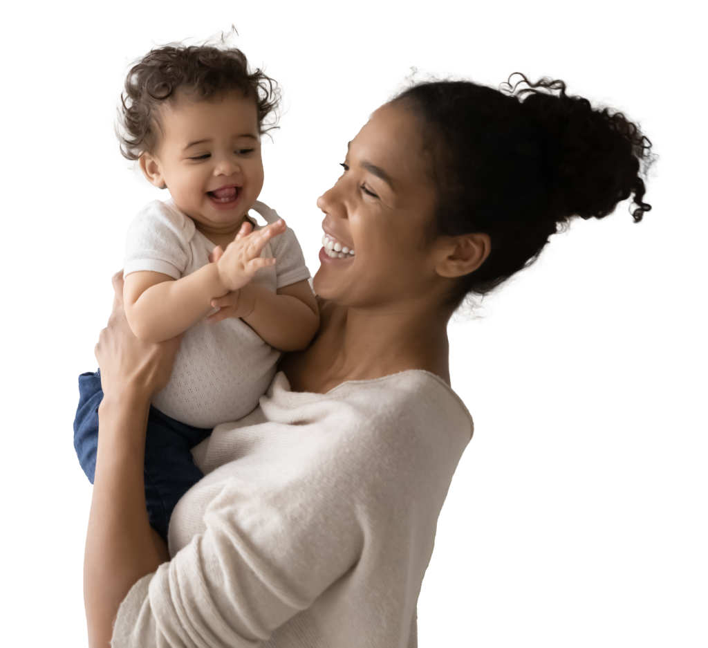 Woman holding a baby smiling.